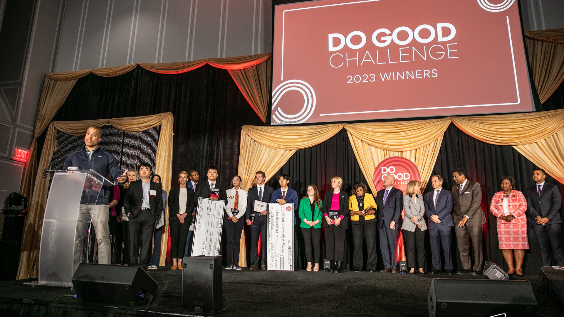All the finalists of the Do Good Challenge 2023 on stage. A large screen above them reads, Do Good Challenge 2023.