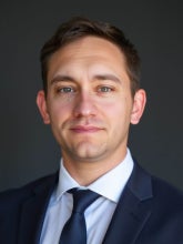 a white man with brown hair wearing a suit and tie