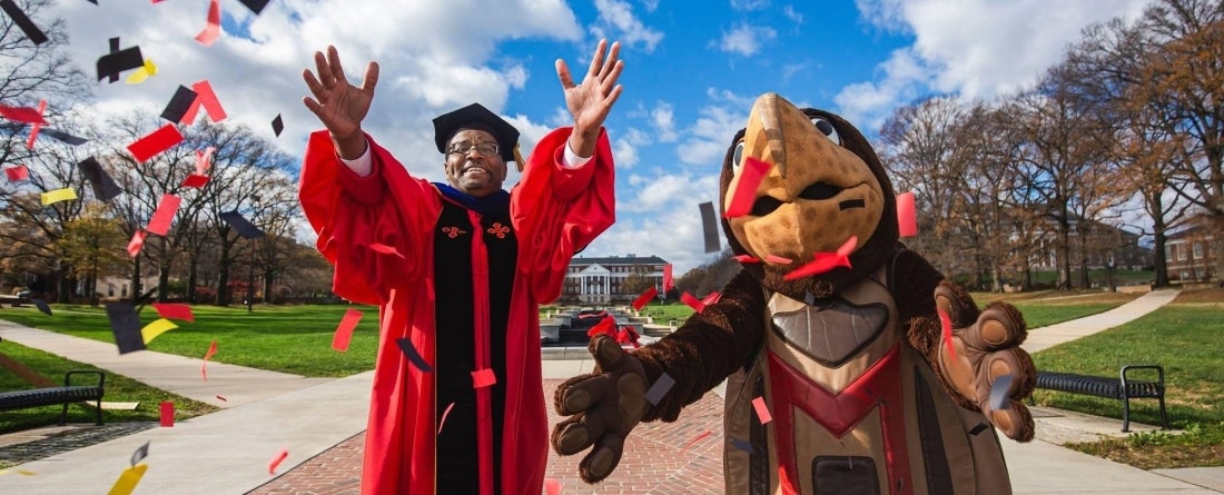 President Pines and Testudo celebrating graduates
