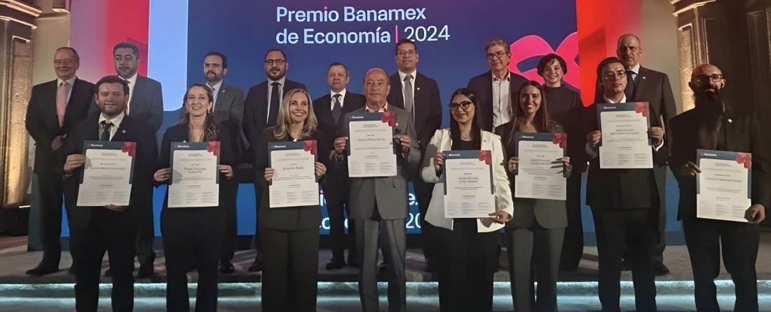 Susan Parker stands on stage with other winners of Premio Banamex de Economia