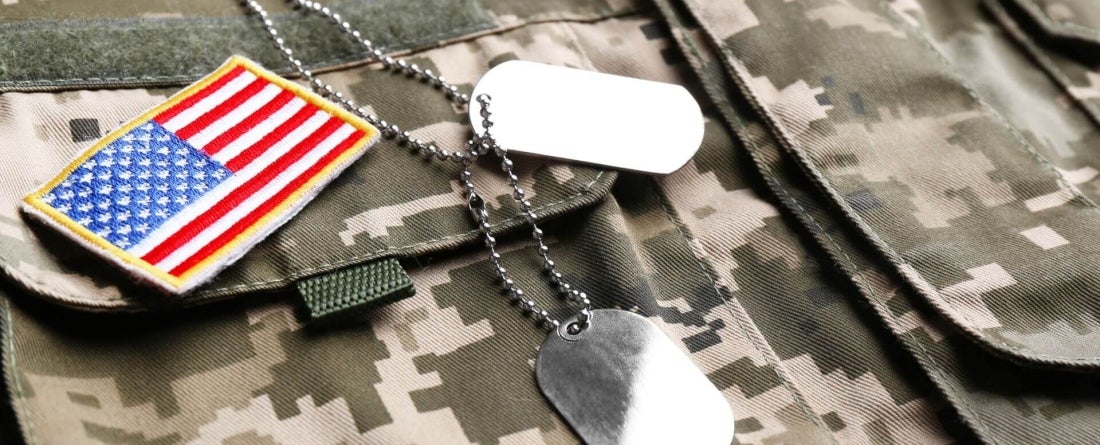 American flag patch and military tags sit atop U.S. Army uniform