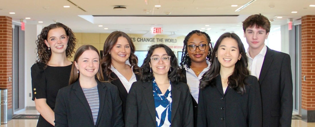 image of group of students standing in front of "change the world" sign
