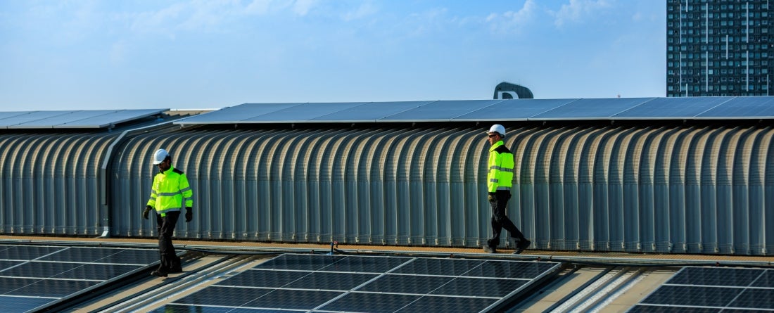 two men on a roof of solar panels